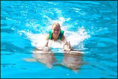A woman with two dolphins.